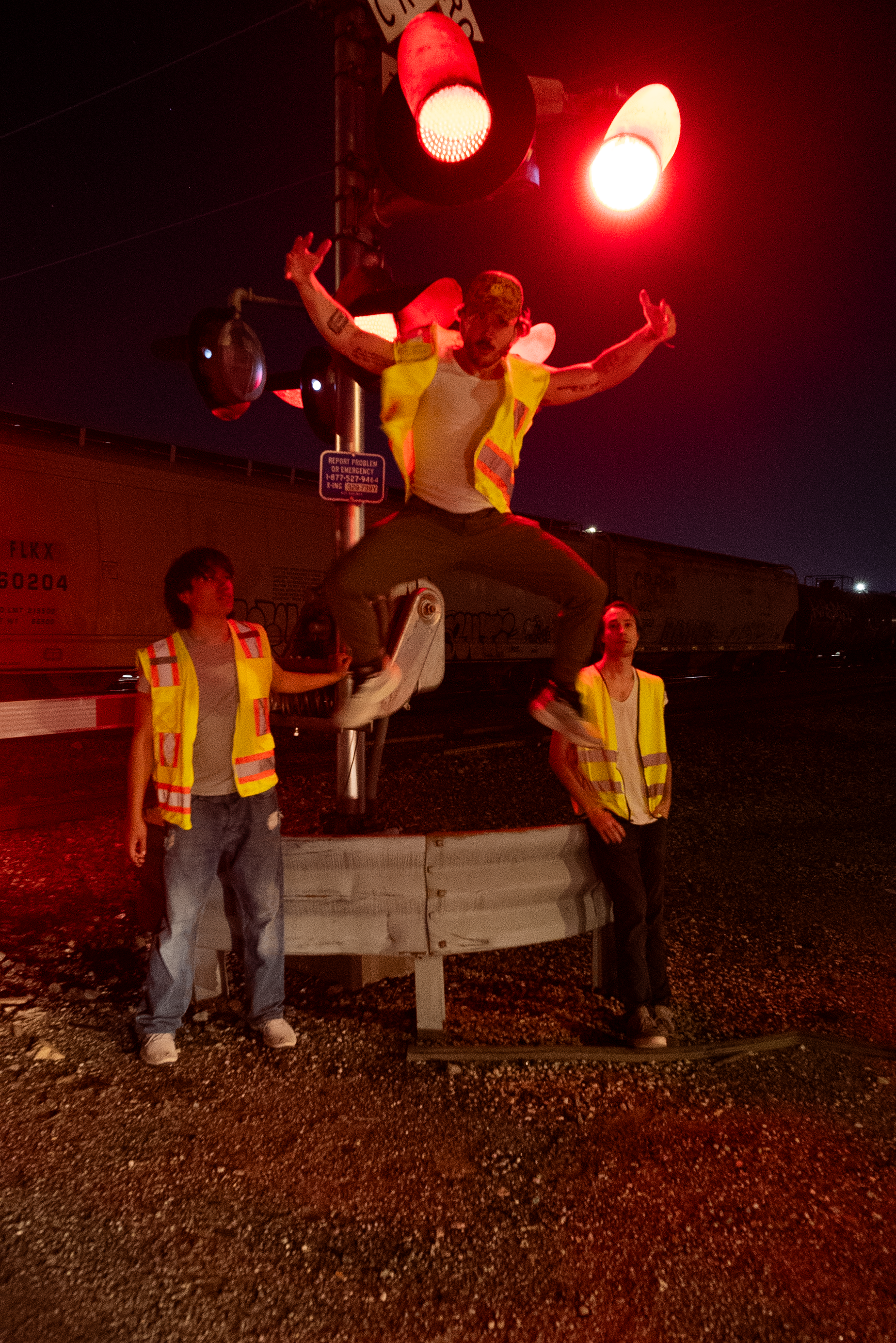 The Thrill of Speed cast at a railroad crossing under red signal lights