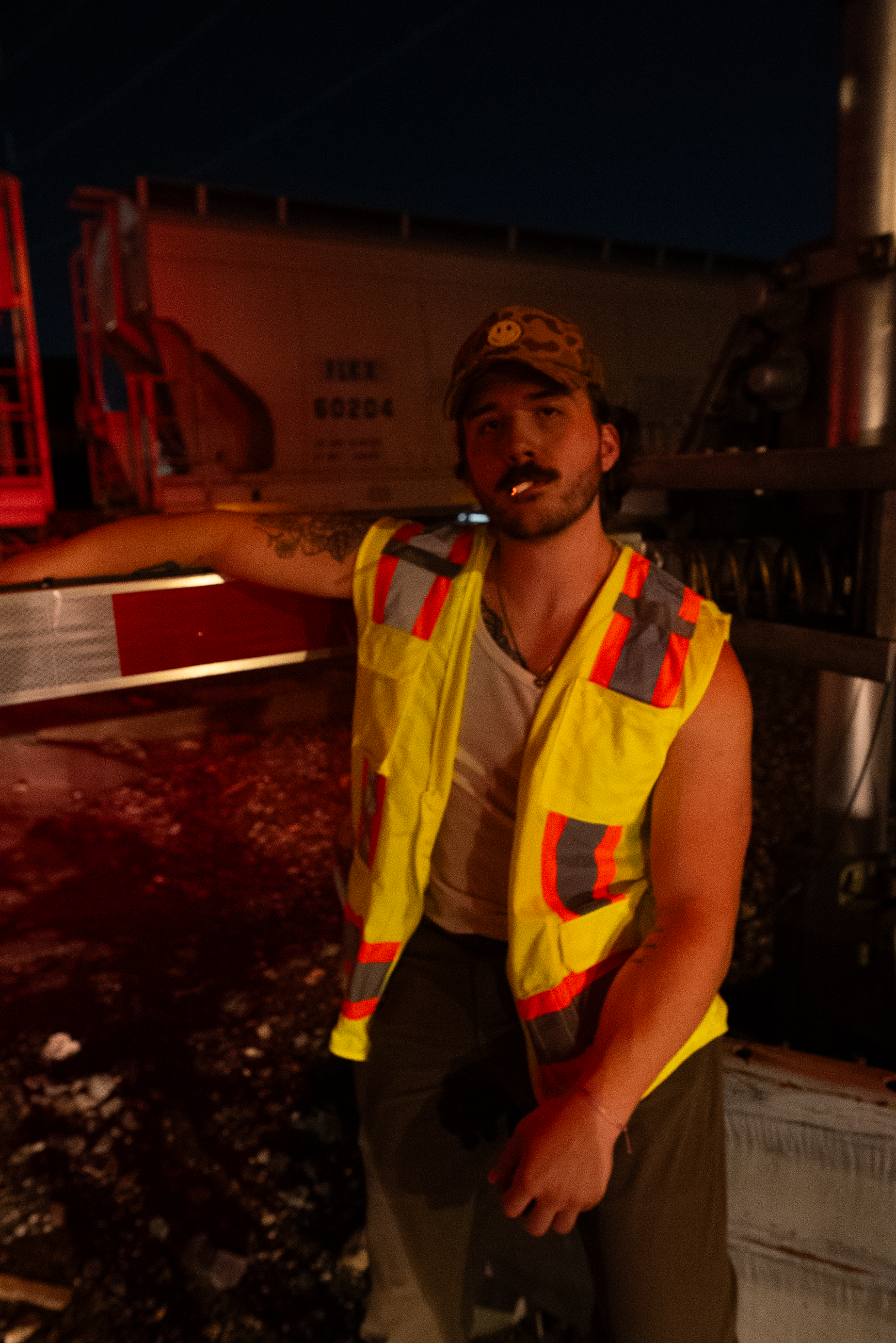 A character from The Thrill of Speed in a safety vest beside rail equipment