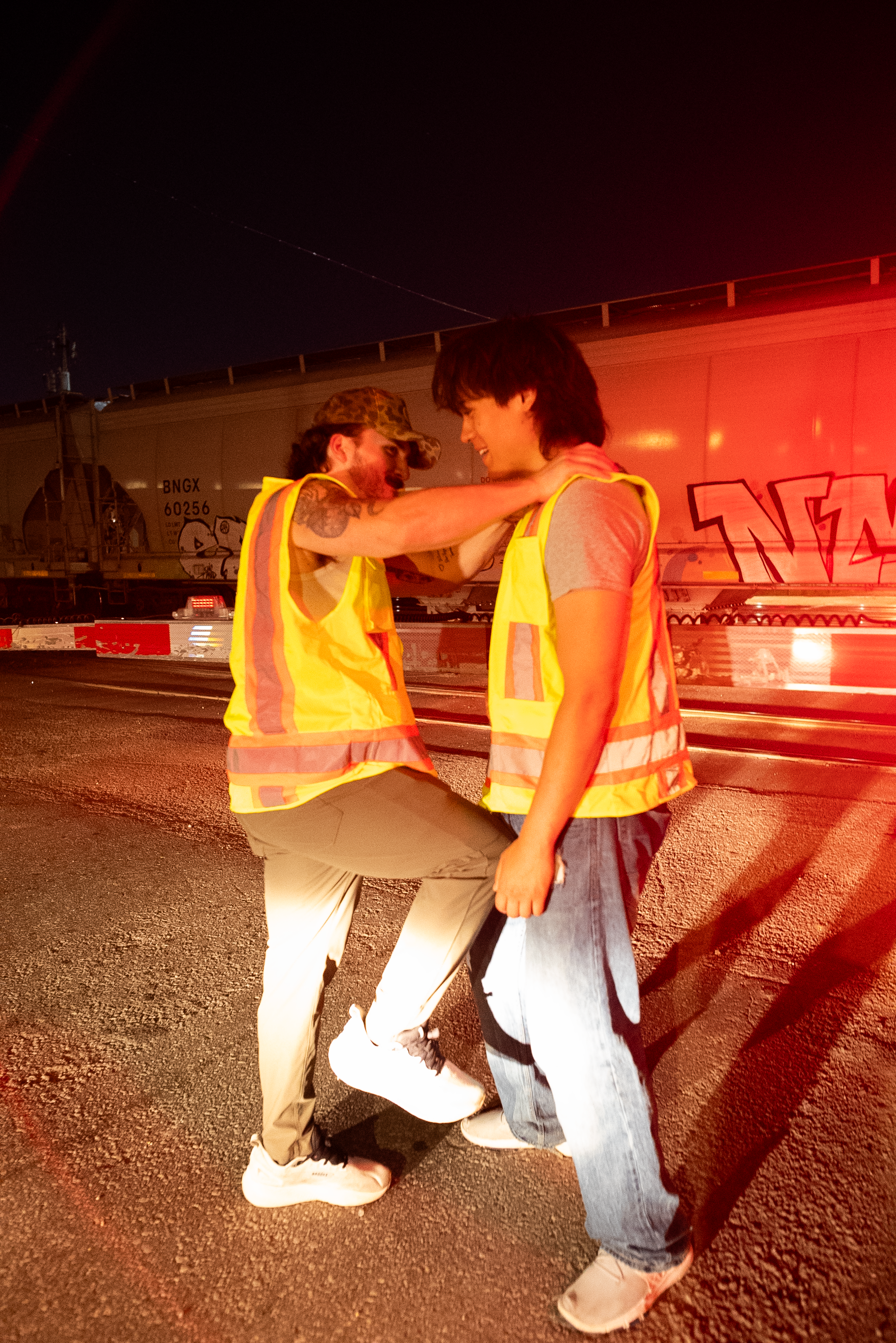 Two characters from The Thrill of Speed joking near a passing train
