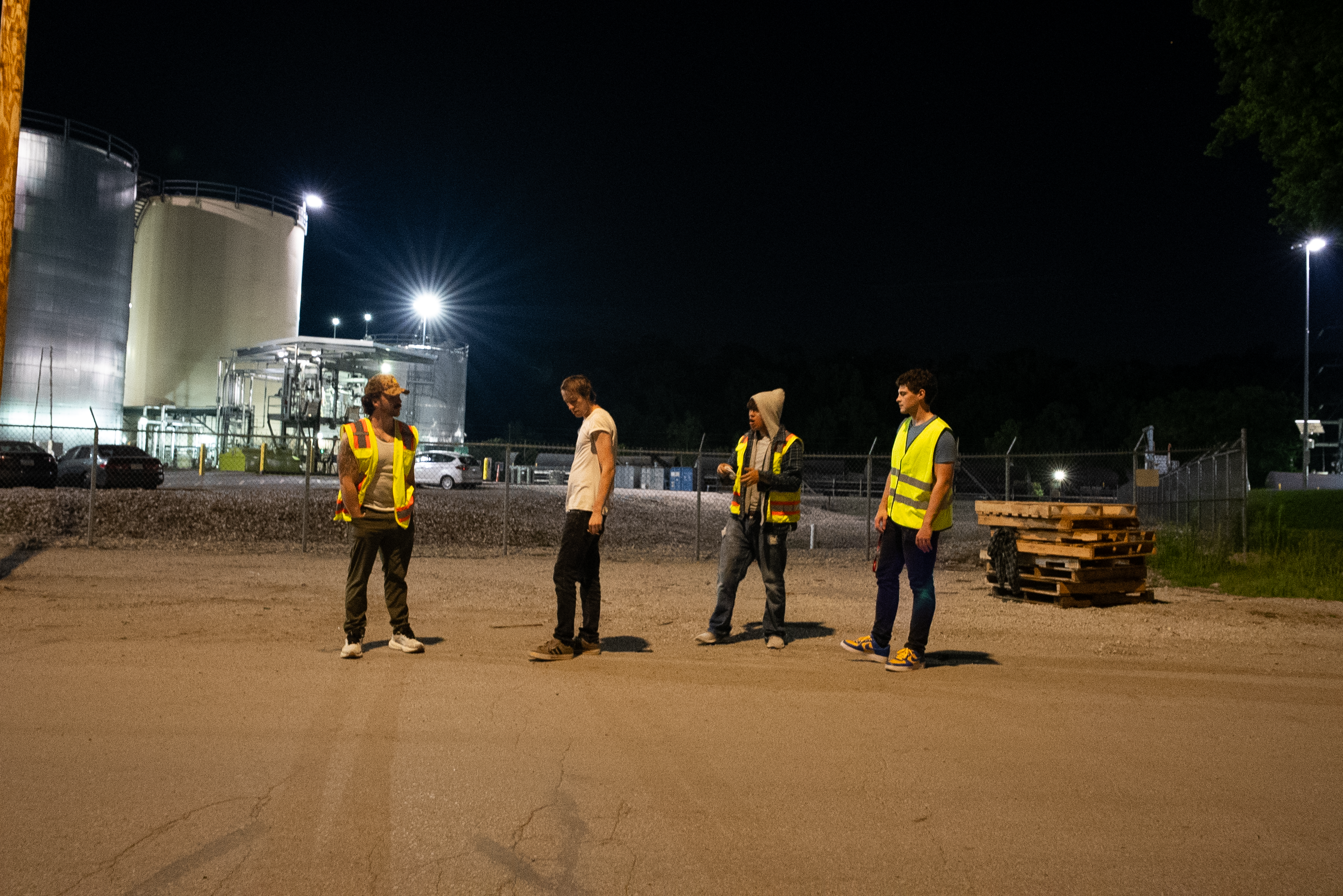 The Thrill of Speed cast standing outside an industrial refinery at night